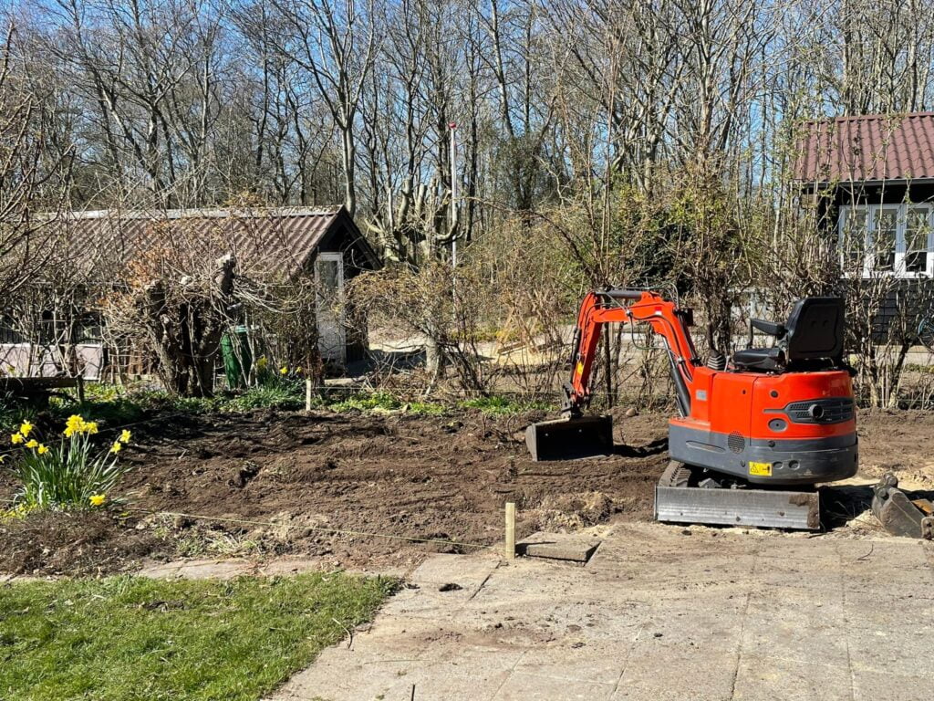 Gravemaskine klar til havearbejde nær hytte